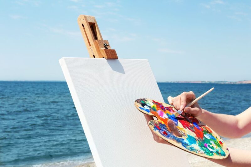 person painting on the beach